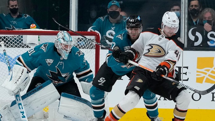 Na snímke uprostred slovenský obranca Sharks Christián Jaroš, vpravo útočník Ducks Max Jones a vľavo brankár Martin Jones.