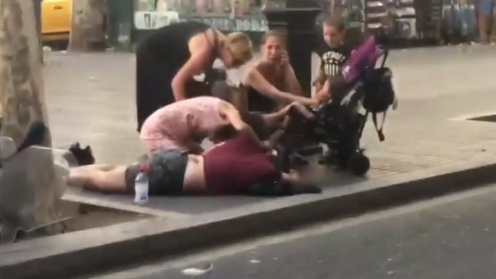 Ľudia pomáhajú obeti útoku.