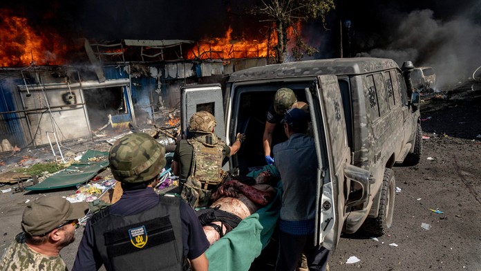 Zranených po raketovom útoku na Ukrajine nakladajú do sanitiek.