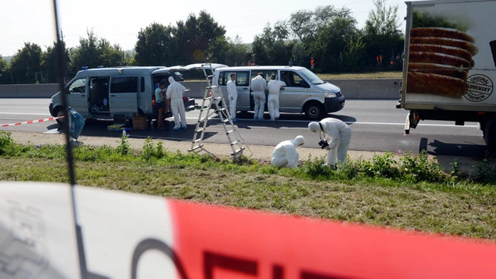 Na snímke policajní a forenzní experti vyšetrujú pri nákladnom aute, ktoré je odstavené na krajnici diaľnice A4 pri rakúskom mes