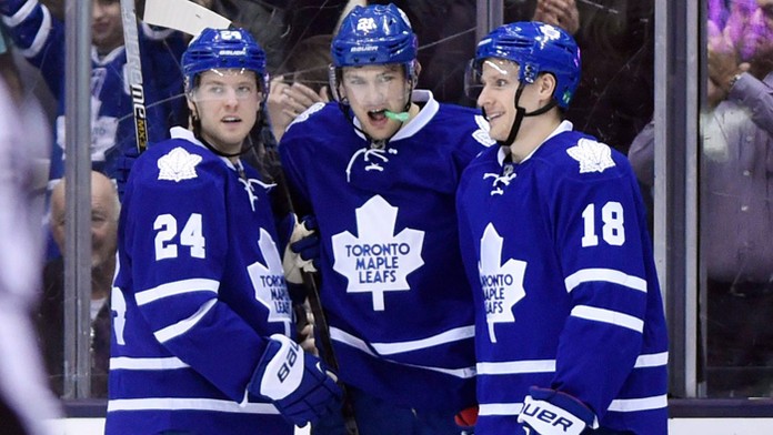 Hráči Toronto Maple Leafs' James van Riemsdyk (v strede), Peter Holland (24) a Richard Pánik.