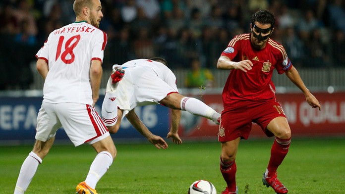 Bielrusi Ivan Maevski (vľavo) a Sergej Kisljak v akcii so španielskym stredopoliarom Cescom Fábregasom.