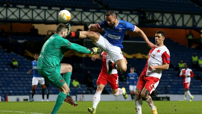 Na snímke vpravo hore hráč Glasgowa Kemar Roofe kope do hlavy českého brankára Slavie Ondřeja Kolářa.