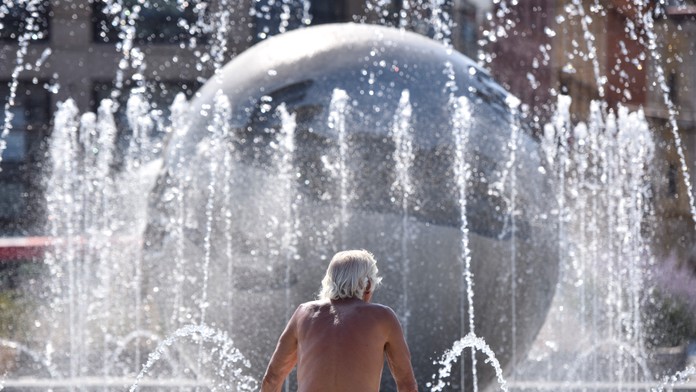 Na snímke muž sa ochladzuje vo fontáne pred Prezidentským palácom v Bratislave.