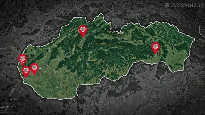 Zdravotník v ochrannom odeve meria teplotu cestujúcej v automobile na hraničnom priechode.