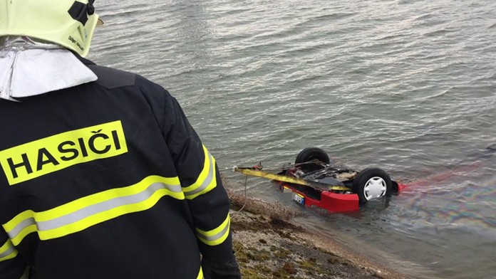 Hasiči vyťahujú auto, ktoré padlo do kanála Váhu pri Sučanoch. 