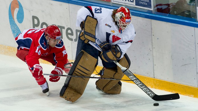 Brankár Slovana Barry Brust a vľavo Geoff Platt (CSKA) počas druhého stretnutia 1. kola play off KHL.