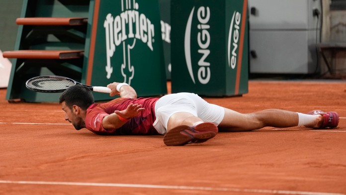 Na snímke srbský tenista Novak Djokovič leží na dvorci.