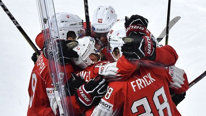 Švajčiarski hokejisti sa tešia po góle do siete Kanady.