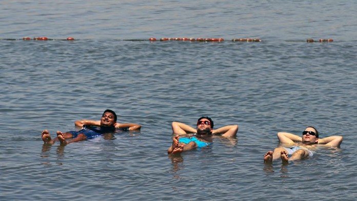 Na snímke ľudia sa kúpu v Mŕtvom mori na západmom brehu Jordánu v meste Jericho počas horúceho dňa.