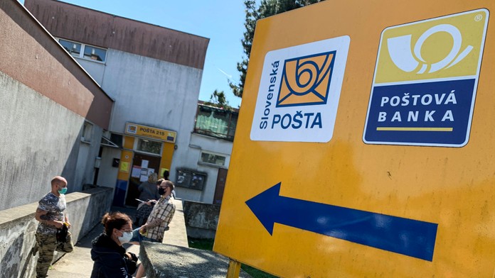 Ľudia pred pobočkou Slovenskej pošty