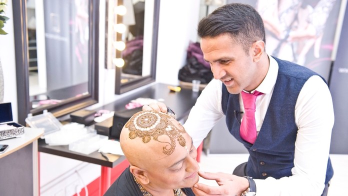 Umelec Ash Kumar maľuje henou korunu pacientke s rakovinou