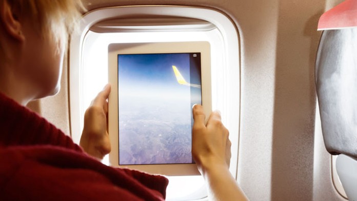 Muž s tabletom v lietadle.
