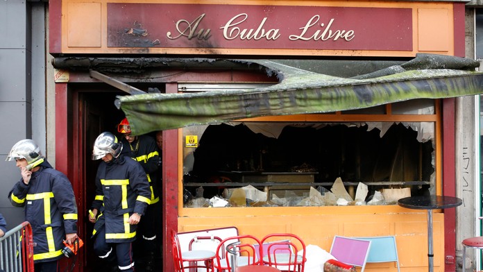 Hasiči vychádzajú z baru, v ktorom požiar zabil 13 mladých ľudí.