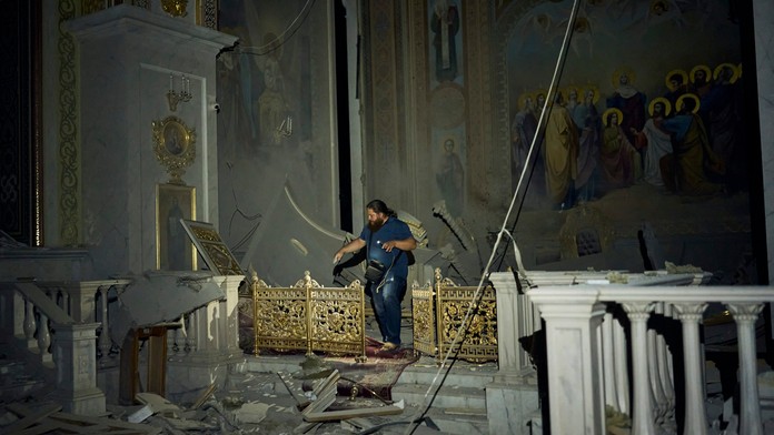 Muž kráča po ťažko poškodenej katedrále v meste Odesa po ruskom útoku.