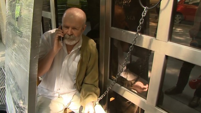 Chcel zabrániť osadeniu pamätníka komunistu. Reťazou sa priviazal k bytovke