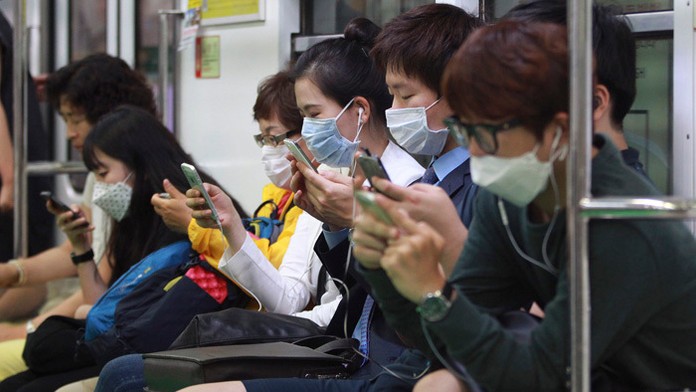 Cestujúci s ochrannými rúškami na tvári.