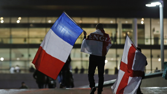 Fanúšik kráča na štadión Wembley s oboma zástavami 