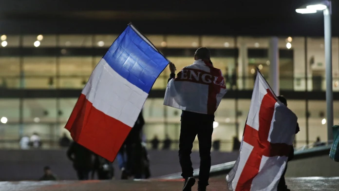 Fanúšik kráča na štadión Wembley s oboma zástavami 