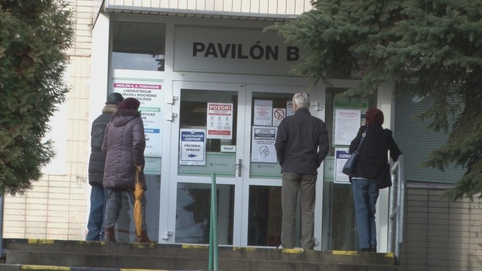 Ľudia čakajú na očkovanie.