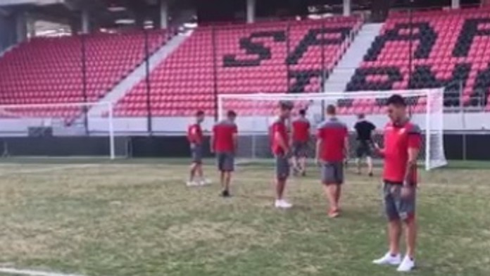 Prekvapení hráči Crvenej zvezdy sledujú trávnik na trnavskom štadióne.