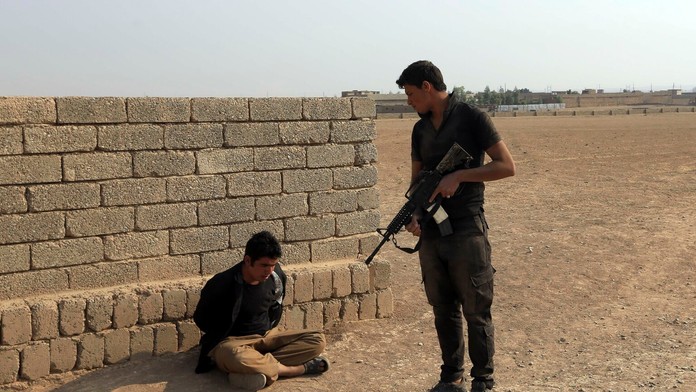 Vojak irackých špeciálnych síl zatýka podozrivého militanta. 