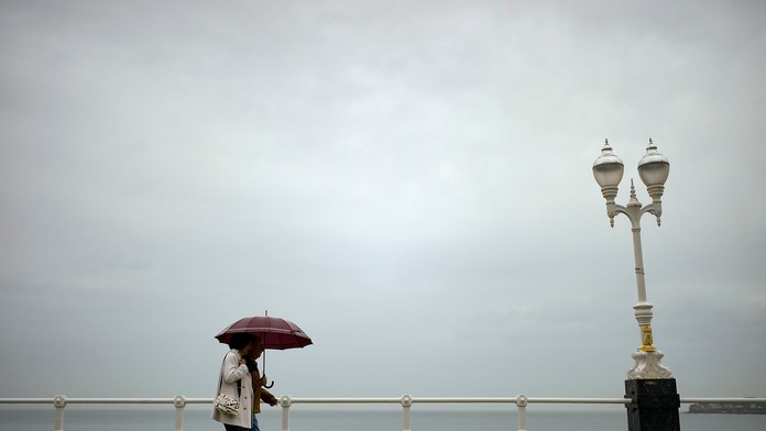 Ľudia s dáždnikom v ruke.