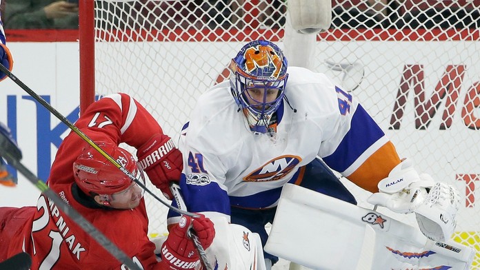 Jaroslav Halák v súboji s hráčom Caroliny Lee Stempniakom v zápase New York Islanders - Carolina Hurricanes.
