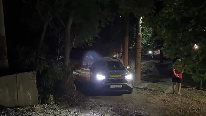 Na snímke polícia, ako odváža zadržaného muža, ktorý susedom hrozil sekerou.