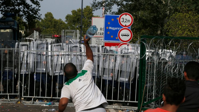 Utečenec hádže smerom k hraniciam s Maďarskom fľašu