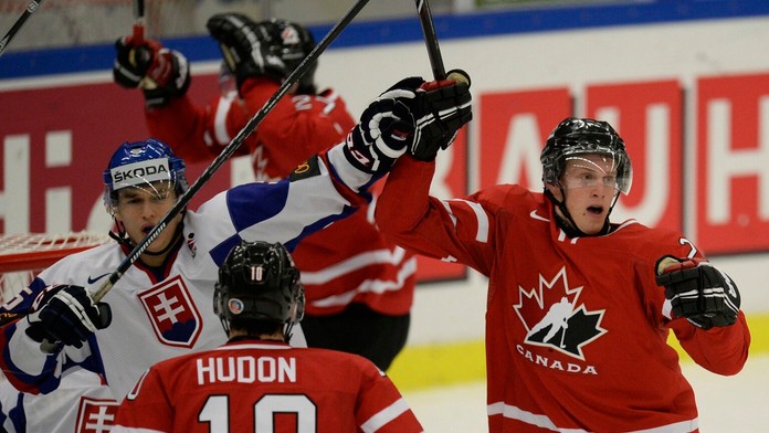 Slovenský hokejový reprezentant Michal Valjent (vľavo) sleduje gólovú radosť hráčov Kanady, vpravo strelec Anthony Mantha.