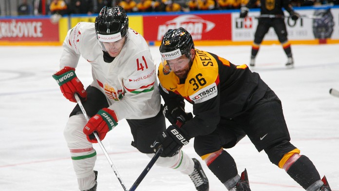 Maďarský hokejista Balázs Sebök (vľavo) a Nemec Yannic Seidenberg bojujú o puk v zápase základnej B-skupiny majstrovstiev sveta 