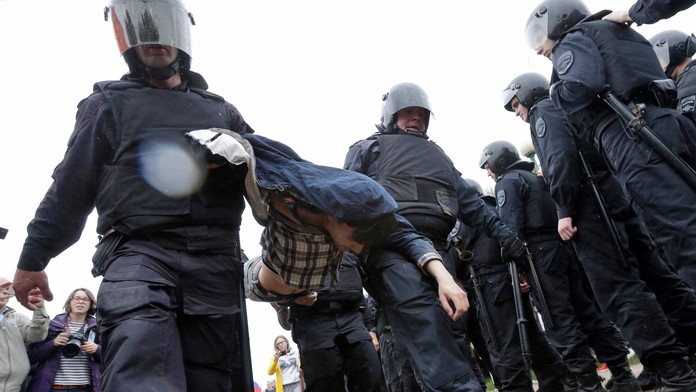Ruská polícia odnáša demonštranta.