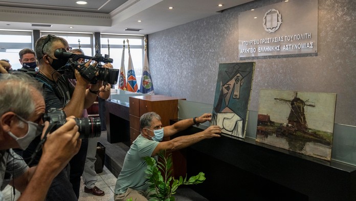 Policajti ukazujú nájdené maľby vľavo španielskeho maliara Pabla Picassa a vpravo holandského maliara Mondriana.