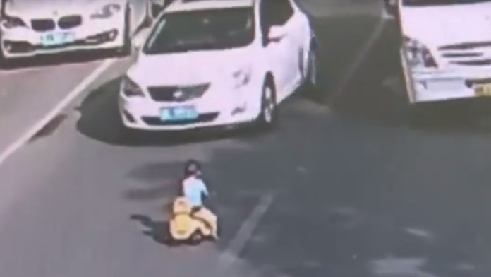 Dieťa sa vozilo na štvorkolke po rušnej ceste.