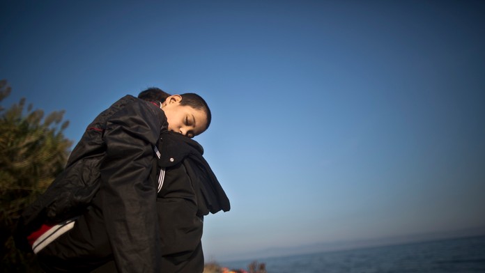 Utečenec nesie na rukách svojho syna