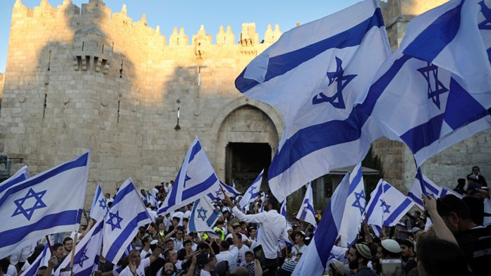 Izraelskí nacionalisti mávajú izraelskými vlajkami.