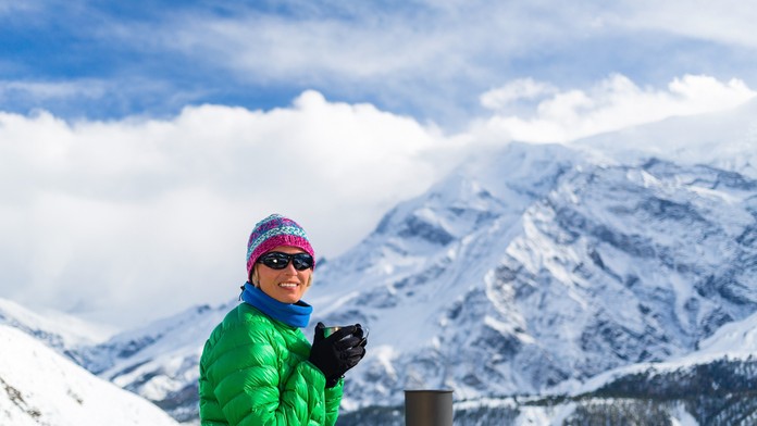 Žena na horách pije čaj - ilustračná snímka.