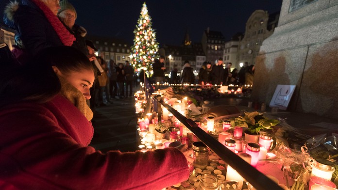 Ľudia zapalujú sviečky na počesť obetí útoku v Štrasburgu.