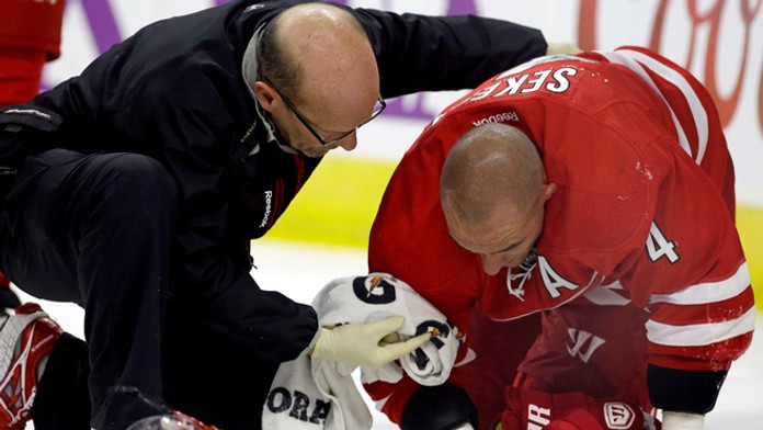 Zranený Andrej Sekera z Caroliny Hurricanes počas ošetrenia v zápase zámorskej NHL proti Buffale Sabres.