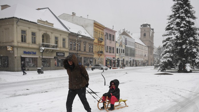 Na snímke žena vezie dieťa na saniach počas sneženia v centre Košíc.