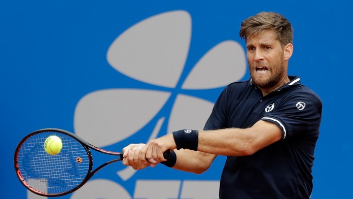 Martin Kližan odvracia úder Mirzu Bašiča z Bosny a Hercegoviny v zápase 2. kola na turnaji ATP v Mníchove.