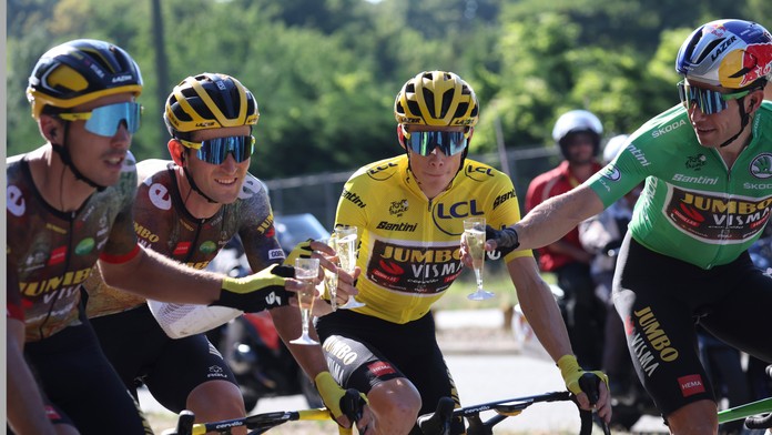 Jonas Vingegaard v žltom drese si pripíja šampanským s kolegami z tímu Jumbo-Visma, 