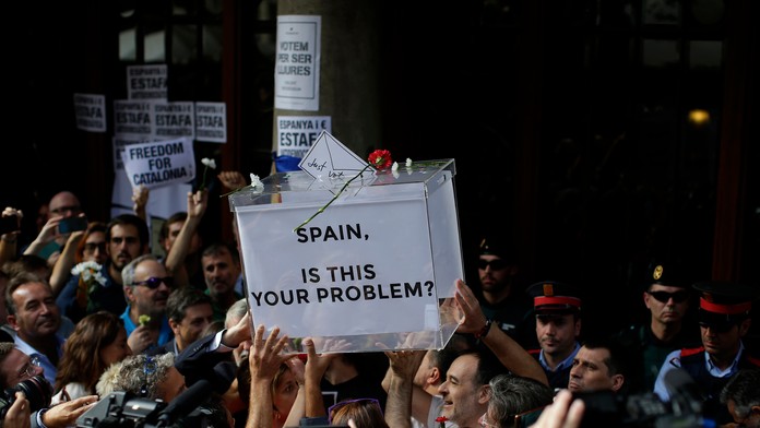 Demonštranti za nezávislosť Katalánska držia volebnú urnu.