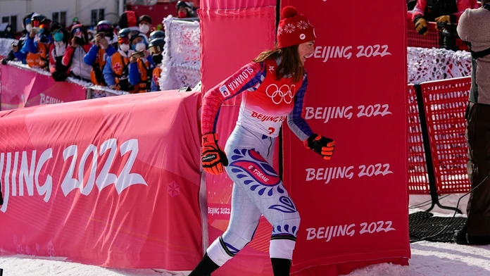 Lyžiarka Petra Vlhová uteká za svojim tímom oslavovať zlato v slalome na ZOH 2022.
