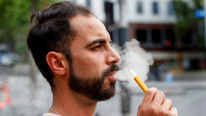 Muž fajčí elektronickú cigaretu.