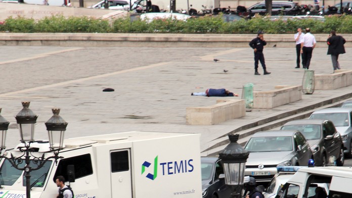 Pred chrámom Notre Dame leží zranený muž.