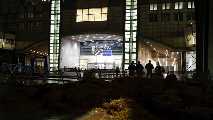 Policajti hliadkujú počas zhromažďovania poľnohospodárov pred Európskym parlamentom pred summitom EÚ.