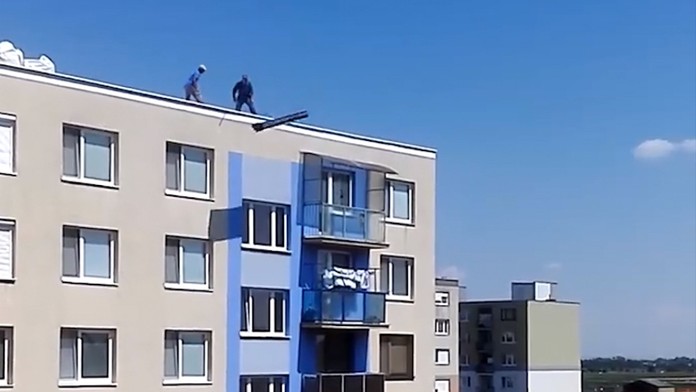 Robotníci vyhadzujú odpad zo stredy paneláka