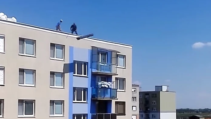Robotníci vyhadzujú odpad zo stredy paneláka
